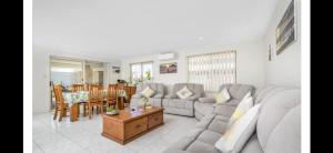 a living room with a couch and a table at Sunset Beach B&B in Waggrakine