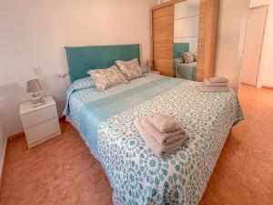 a bedroom with a large bed with towels on it at Encantador Apartamento en Primera Línea de Playa in Villajoyosa