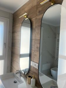 a bathroom with a mirror and a sink at Cassino - Appartamento Demetra - Parco del Gari in Cassino +4 photos