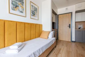a bedroom with two beds and a wooden headboard at Zeus Apartments Lublin in Lublin
