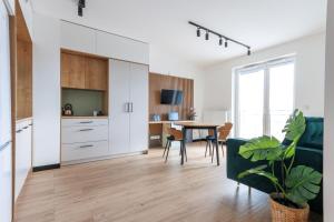 a kitchen and dining room with a table and chairs at Zeus Apartments Lublin in Lublin