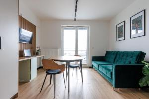a living room with a green couch and a table at Zeus Apartments Lublin in Lublin