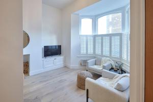 a living room with white furniture and a tv at Pier View in Saltburn-by-the-Sea
