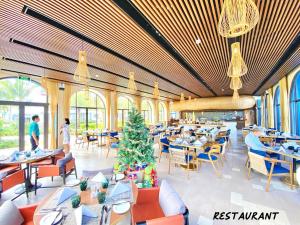 a restaurant with tables and a christmas tree in the middle at Luxury SeaView Apartment in 5 star Resort, An Bàng - Hội An in Dien Ban