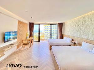 a hotel room with two beds and a television at Luxury SeaView Apartment in 5 star Resort, An Bàng - Hội An in Dien Ban +23 photos