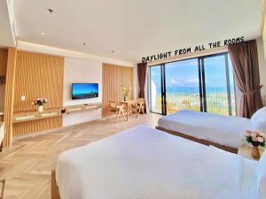 a hotel room with two beds and a television at Luxury SeaView Apartment in 5 star Resort, An Bàng - Hội An in Dien Ban