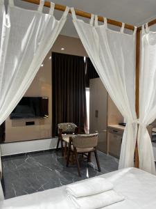 a bedroom with a bed and a table and chairs at Hotel The Octave in Surat