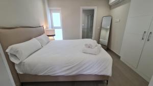 une chambre avec un lit blanc avec des serviettes dessus dans l'établissement Navas PentHouse 301 By Florentia Homes, à Grenade