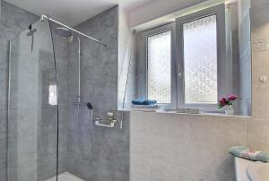 a bathroom with a shower with a glass shower backdoor at Plain pied en rez de jardin à la campagne et proche de l'océan in Mahalon +14 photos