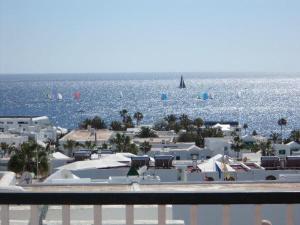 widok na plażę z łodzią w wodzie w obiekcie Casa Josephine Lanzarote, spectacular sea views & FREE WiFi w Puerto del Carmen