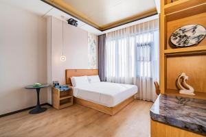 Postel nebo postele na pokoji v ubytování 安汇文化酒店 朝阳高铁站石佛营地铁站店