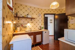 Una pequeña cocina con fregadero y refrigerador. en Ca’ Ser, en Miazzina