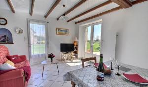 a living room with a red couch and a table at Plain pied en rez de jardin à la campagne et proche de l'océan in Mahalon