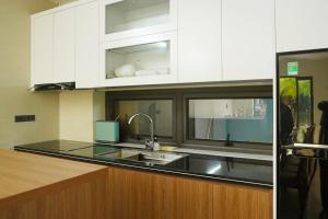 a kitchen with white cabinets and a sink at Sen Villa Tam Cốc in Nguyễn Thôn