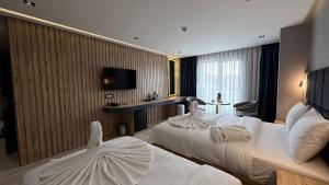 a hotel room with two beds and a television at Karaca Hotel Van in Bostaniçi