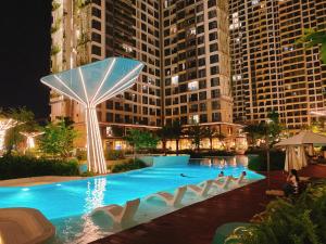 una piscina en una ciudad por la noche con edificios altos en LuxeNest VN, en Gò Công