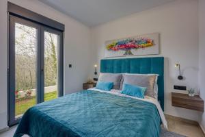 una camera da letto con un letto blu e una finestra di Villa Gigi - Happy Rentals a Višnjan (Visignano)