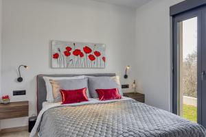 una camera da letto con un letto grande con cuscini rossi di Villa Gigi - Happy Rentals a Višnjan (Visignano)