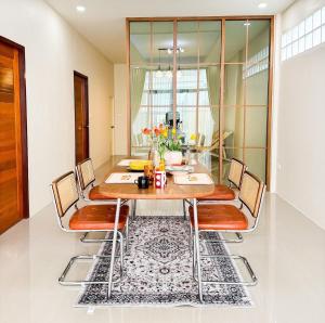 a dining room with a wooden table and chairs at Yolo House In Narathiwat in Kampong Botong