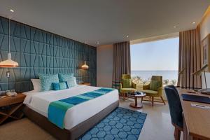 a hotel room with a bed and a desk and chairs at The Park Visakhapatnam in Visakhapatnam