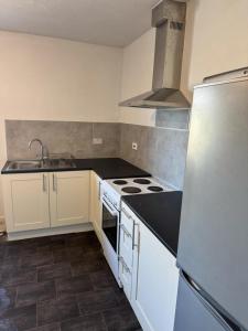 a kitchen with white appliances and a black counter top at One Bedroom Apartment - Swansea Centre & Train stn in Swansea