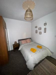 a bedroom with a bed with two yellow towels on it at One Bedroom Apartment - Swansea Centre & Train stn in Swansea +8 photos