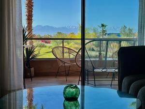 a room with a glass table and a view of a balcony at Marrakech golf City prestigia in Marrakesh