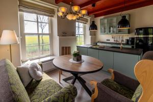 a kitchen with a table and chairs in a kitchen at Ferienhaus Lüsthuus in Manslagt