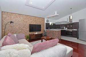 a living room with a couch and a kitchen at Apartment & Rooms Meri Tučepi in Tučepi