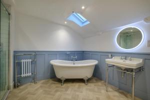 a bathroom with a tub and a sink and a mirror at Corner House in Ambleside +17 photos
