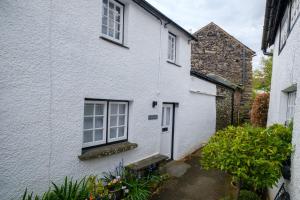 a white house with a window and a door at Corner House in Ambleside