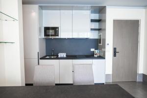 a kitchen with white cabinets and two chairs at Unit For Living in Beirut