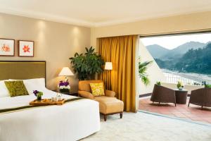 a hotel room with a bed and a large window at Grand Coloane Resort in Macau
