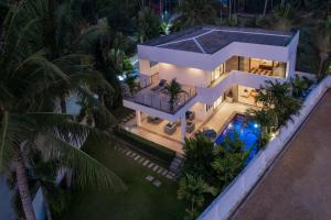 an aerial view of a house at night with a swimming pool at Baan Siri Varee - Private Village Luxury in Ban Tai, Koh Samui in Mae Nam