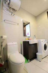 a bathroom with a toilet and a sink and a washing machine at Bay Point Love Bed Danga Bay in Johor Bahru