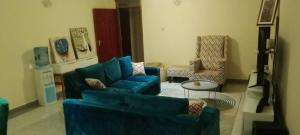 een woonkamer met twee blauwe banken en een tafel bij The Blissful Pitstop in Gatunga