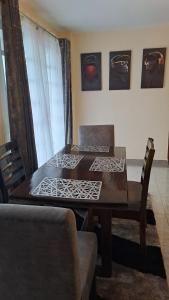 een eetkamer met een houten tafel en stoelen bij The Blissful Pitstop in Gatunga