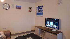 een woonkamer met een flatscreen-tv op een tafel bij The Blissful Pitstop in Gatunga