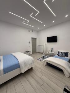 a bedroom with two beds and a television on the ceiling at Le Pupatelle Apartment in Castellammare di Stabia