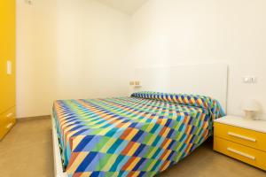 a bed with a colorful comforter in a bedroom at Centonze appartamenti in San Foca