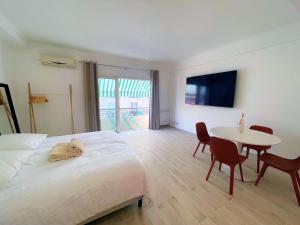 " Pasteur " CityCenter - Terrasse - Congres - VUE MER - Elégant في كان: غرفة نوم بها سرير أبيض وطاولة وكراسي