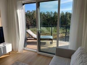 a living room with a sliding glass door at Apartament BRYZA Marina Borki in Augustów