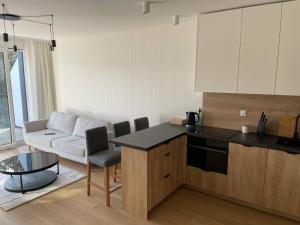 a kitchen and living room with a couch and a table at Apartament BRYZA Marina Borki in Augustów