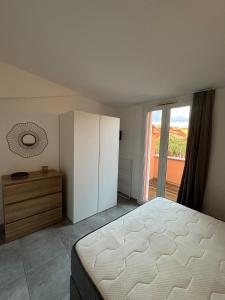 a bedroom with a bed and a dresser and a window at Appartement 32 - Résidence les Hameaux de Saint Cyprien in Lecci