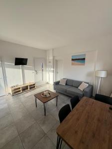 a living room with a couch and a table at Appartement 32 - Résidence les Hameaux de Saint Cyprien in Lecci