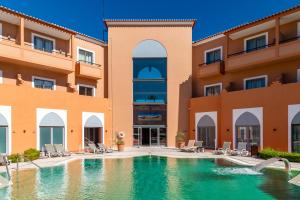 a hotel with a swimming pool in front of a building at Pestana Sintra Golf Resort & SPA Hotel in Sintra