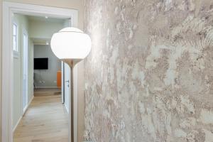 a floor lamp in a hallway with a stone wall at Bmi Florence rooms in Florence
