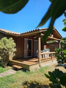 a house with a wooden deck with a bench at AE village in Gastes