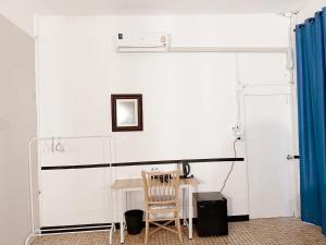 a white room with a table and a chair at Toss Inn Hat Yai in Hat Yai