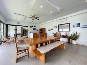a dining room with a wooden table and chairs at Ananda Villa Yeh Gangga by The Lavana - 4 Bedroom Villa with Private Pool in Krambitan